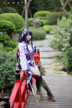 Portrait of a beautiful young woman game cosplay with samurai dress costume on Japanese garden
