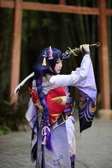 Portrait of a beautiful young woman game cosplay with samurai dress costume on Japanese garden