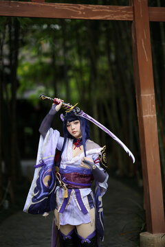 Portrait of a beautiful young woman game cosplay with samurai dress costume on Japanese garden