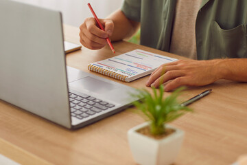 Cropped photo of businessman writing tasks and to do list in plan schedule calendar sitting at the...