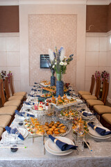 Stylish table setting with delicious party food and beautiful floral centerpiece