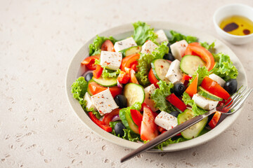 Greek salad of fresh cucumber, tomato, sweet pepper, lettuce, red onion, feta cheese and olives with olive oil. Healthy food
