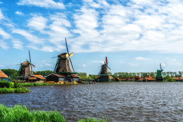 Fototapeta na wymiar Traditional Dutch windmills with canal in Zaanse Schans near the Amsterdam, Holland