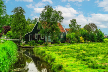 Fototapeta na wymiar Picturesque view of traditional Houses by the Canal in the Historic Village of Zaanse Schans, The Netherlands