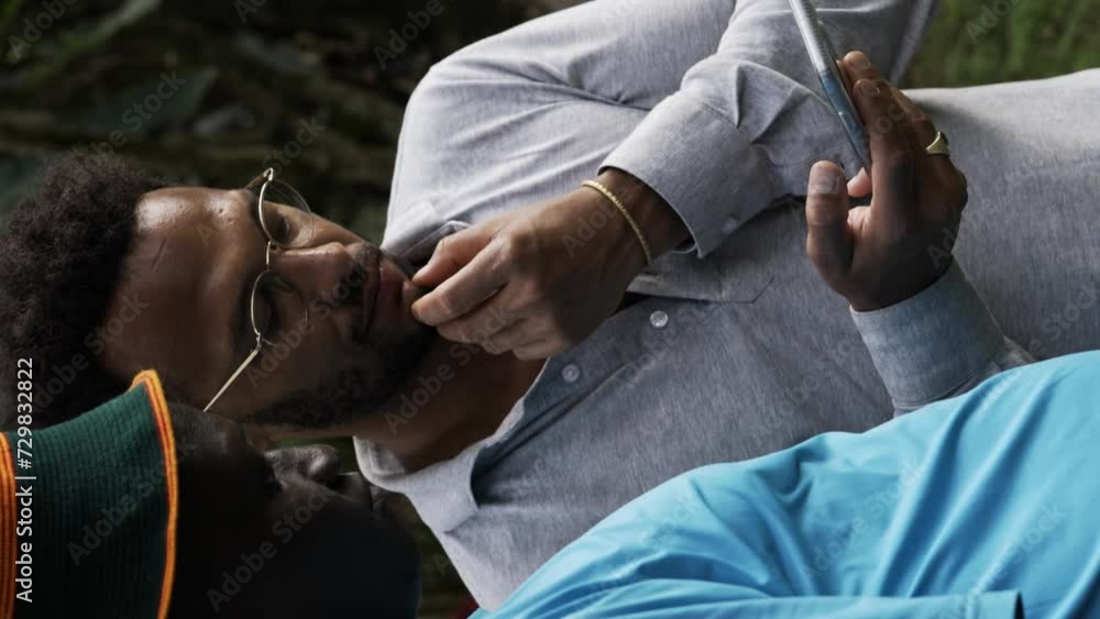 Poster afro american men viewing a phone screen while using a mobile device - vertical shot