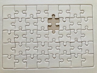 an all-white jigsaw puzzle with the missing piece on it in the close-up shot, valentine concept