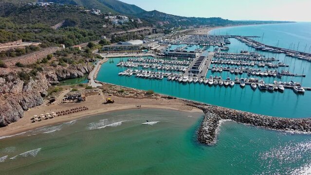 Port ginesta marina full of boats with a beach and breakwater, near barcelona, spain, sunny day, aerial view