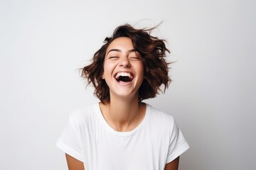Happy young woman laughing with her hair fluttering in the wind. - obrazy, fototapety, plakaty