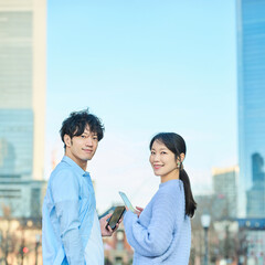 スマートフォンを手に笑顔の男女