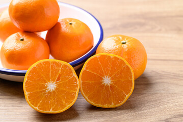 Mandarin orange fruit in bowl on wooden background, Tropical fruit