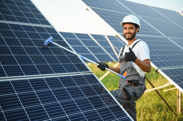 Indian worker cleaning solar panels.