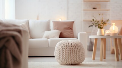 Cozy and stylish living room with white sofa, knitted pouf, and terra cotta accents. Scandinavian, hygge-inspired interior design with natural light and warm colors.