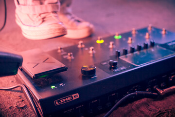 Closeup photo of Line 6 guitar pedalboard with some feet in the background