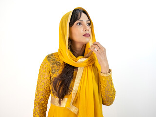Indian woman posing in a vibrant yellow Anarkali suit, adorned with embroidery. 