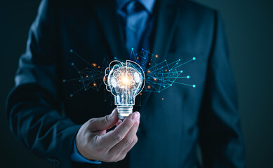 Businessman holding illuminated lightbulb, idea, innovation and inspiration with glowing virtual...