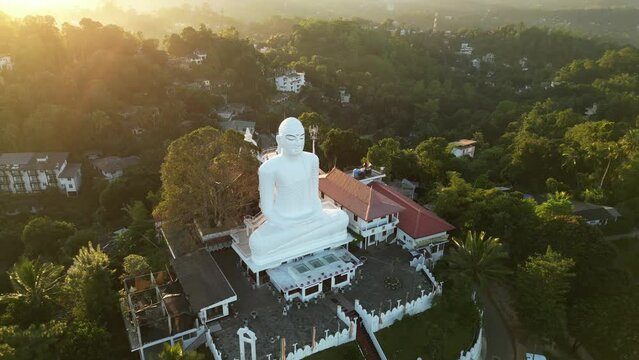 Big White Buddha statue on the top of the hill in Kandy, Sri Lanka. Aerial view of Sri Maha Bodhi buddhist Temple