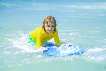 Child summer vacation at sat. Summer vacation with child. Surfer child is riding a wave. Kid learning to surf in sea or ocean.