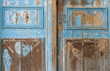 Detail of a beautiful blue weathered wooden door in Beaucaire, Provence, south of France, Gard.