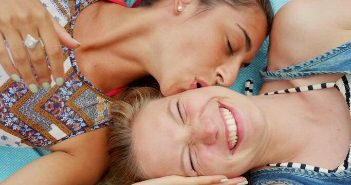 Lesbian couple, selfie and kiss on a picnic blanket outdoor with smile, care or moment from above. LGBTQ, face and happy women bonding outside with trust, romance and social media profile picture