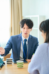 女性に向かって話すスーツ姿の男性