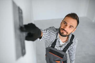 Young worker making repair in room.