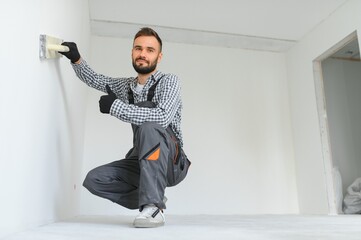 Young worker making repair in room.