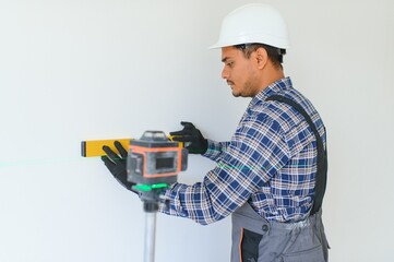 An Indian worker works in an empty apartment. A man in a uniform makes repairs inside the building