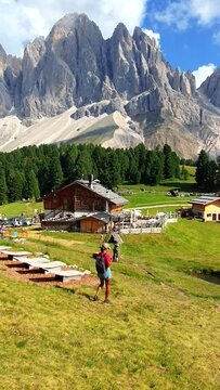 a woman hiking in the mountains of Val Di Funes in Italian Dolomites Adolf Munkel Trail in Puez Odle Nature Park
