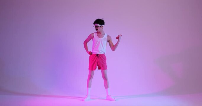 Funny 80s nerdy Caucasian man in sportswear doing bicep exercise with dumbbell over purple background. Fitness, workout, gym concept.