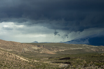 Spectacular desert landscape in the Peruvian Altiplano in the Andes Mountains between Cabanaconde and Arequipa, Peru, hills. Storm, dramatic sky. Chiaroscuro.