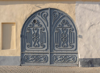 Old iron wrought iron door in the wall