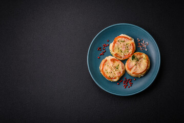 Delicious baked fish fillet with cheese, tomatoes, salt, spices and herbs