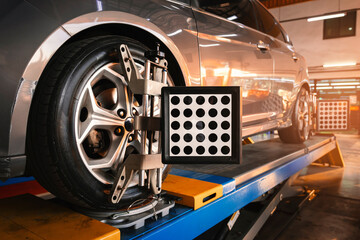 Car wheel alignment is in progress. auto camber toe check fixing. sensor during suspension adjustment and automobile wheel alignment work at the repair service station
