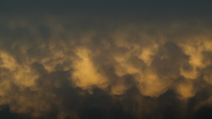 Coucher de soleil sous les nuages, révélant de magnifiques reflets jaunâtres sous des nuages de type Mammatus