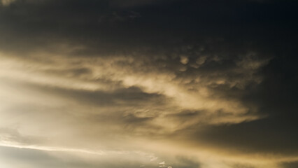 Coucher de soleil sous les nuages, révélant de magnifiques reflets jaunâtres sous des nuages de type Mammatus