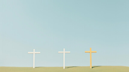 Three white and brown crosses on a hill against a blue sky background