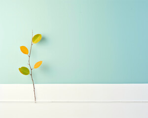 Single branch of a plant with green and yellow leaves isolated on a blue background.