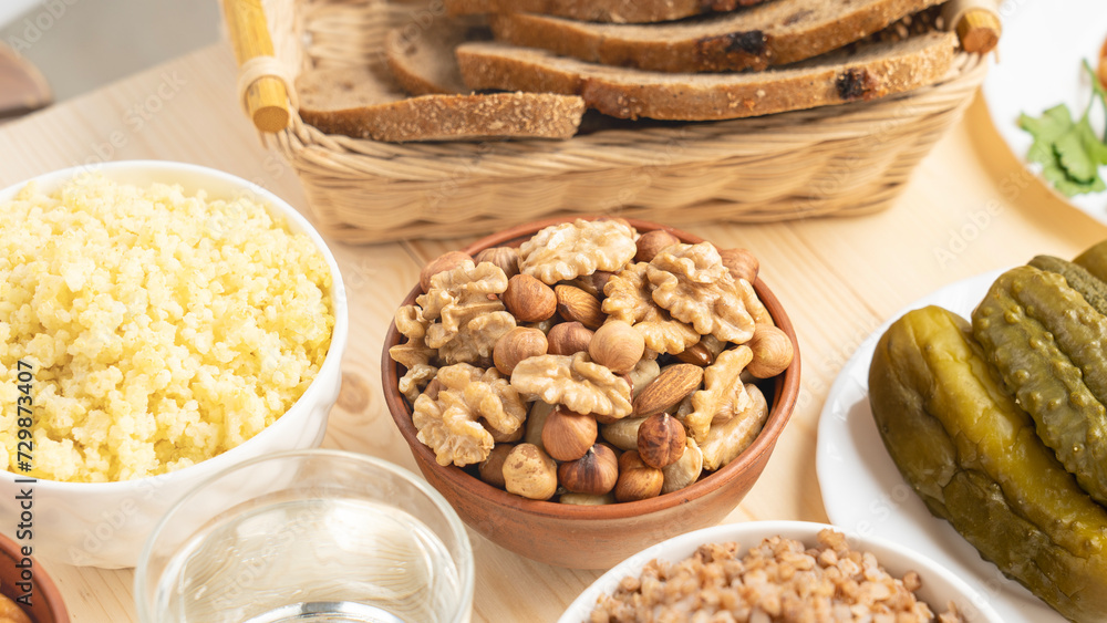 Wall mural a mixture of nuts and cereal porridge on a wooden table, healthy and wholesome food concept