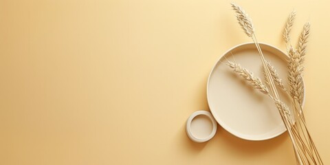 Different size plates and ears of wheat spikelet on golden wheat colour background. Flat lay, top view, space for text. Natural beige colour palette, minimalist style