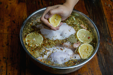 male hand squishing fresh lemon to salt water brine, adding flavor and acidity, concept of brining...