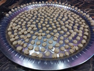 White urad dal big in a big steel plate,Grease the plates with oil,fill the entire plate with balls.White Gram Whole,White urad dal big in a big steel plate,Udad Badi on a big steel plate