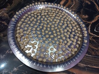 White urad dal big in a big steel plate,Grease the plates with oil,fill the entire plate with balls.White Gram Whole,White urad dal big in a big steel plate,Udad Badi on a big steel plate