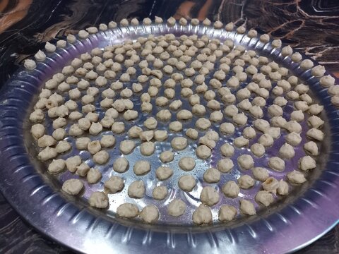 White urad dal big in a big steel plate,Grease the plates with oil,fill the entire plate with balls.White Gram Whole,White urad dal big in a big steel plate,Udad Badi on a big steel plate