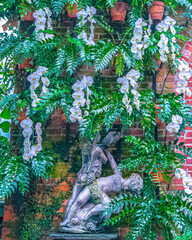 wall of white orchids with a statue in the middle 