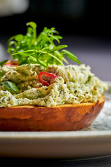 Toast with cream cheese and greens in a plate