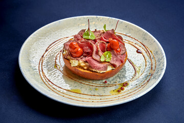 Toast with roast beef and vegetables in a plate