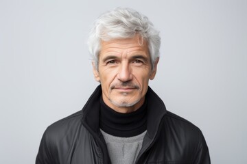 Portrait of senior man with grey hair wearing black jacket and looking at camera.