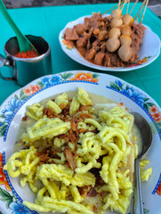 Kupat Glabed is a typical food from Brebes, Central Java, Indonesia. Served with Satay Blengong. Food traditional. Selective focus. 