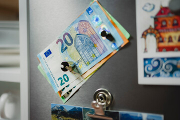 Geld mit Magneten am Kühlschrank