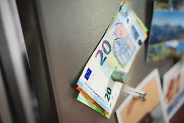 Geld mit Magneten am Kühlschrank